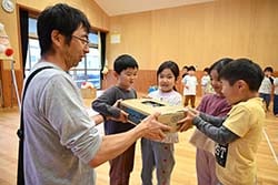 園児に新鮮な野菜を手渡す部員