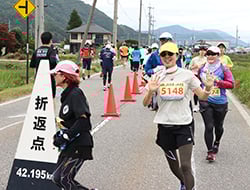 折り返し地点を笑顔で走るランナー