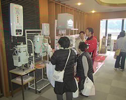 ガス機器の説明を聞く来場者