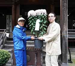 菊花を受け渡す奥山会長（左）と渡部宮司（右）