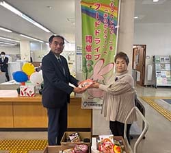 食品を社会福祉協議会職員へ手渡す久保部長