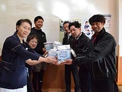 施設消毒用ウェットティッシュを寄贈する鈴木実行委員長（右前）ら