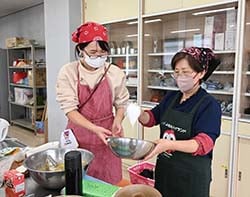 シフォンケーキのつくり方を教える平田理事（右）