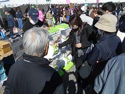 カプセルトイ「やまガチャ段ボール」を回す来場者ら（9日、長野県東筑摩郡にて）