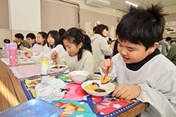 つきたてのお餅をほおばる児童ら