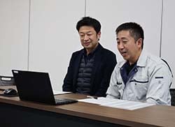 永明中学校1年生とリモートで繋がり、茅野市の農業の魅力や課題を説明する折井統括所長（左）と湯田坂所長代理（右）