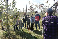 「サンふじ」の収穫方法に耳を傾ける参加者たち