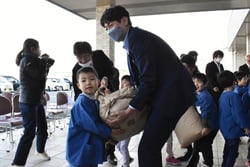 JA職員と一緒にトラックを米を積み込む児童
