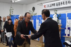 白鳥常務から表彰状を受け取る品評会の金賞受賞者