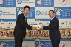 丸山専務（左）が宮之上会長へ手渡した