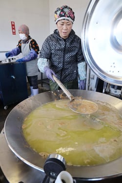 リンゴの果汁を絞り、大鍋で加熱する部員