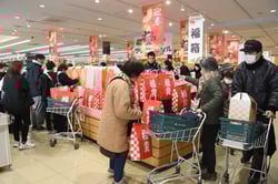 福箱に多くの来店客が手を伸ばす
