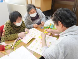 家の光の冊子を見ながらリース作りを行う女性部員ら