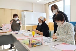 溝口さん（左）のアドバイスのもと、「干支の折り紙」づくりを楽しむ部員（長野県茅野市で）