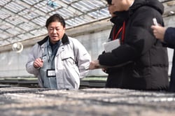 JA育苗センターの仕事内容を説明する森山所長代理（左）