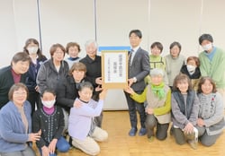 義援金を届ける女性部員らと宮澤支所長（中央）