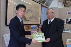 教材を手渡す根橋部長（左）