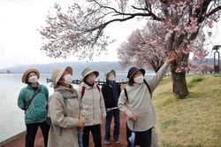 咲き始めた桜に笑顔を見せる部員