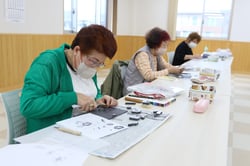 転写された図案に沿って消しゴムを彫る参加者
