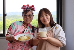 完成した塩糀カレーを持つ武井部会長（左）と塩糀を持つ小林さん（右）