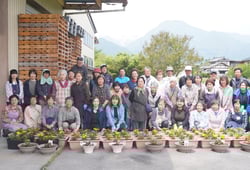 寄せ植えを前に笑顔を見せる参加者ら（安曇野市穂高有明）