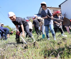 松木さん（左）の指導のもと、耕運機を使って耕す児童