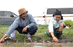 田植えを見守る田中青年支部長（左）と生徒
