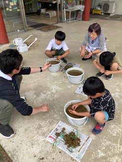 営農技術員の指導で田植えをする子どもたち