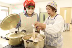 湯煎された料理の状態を確認する院生
