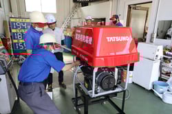 緊急用発電機の操作方法を確認する社員