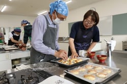 小林担当（右）のアドバイスのもと、ウィンナーパンを仕上げる受講生