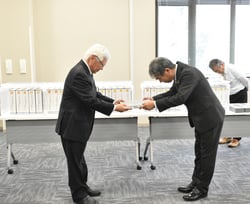 竣工書類の引き渡しを行う株式会社守谷商会と宮澤清組合長㊧