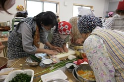 青山さん（左）の指導で薬膳料理を熱心に学ぶ部員ら
