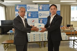 冷し中華を手渡す眞島組合長