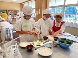 女性部員からおやき作りを学ぶ児童たち