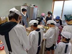 支部員のアドバイスを受けながら調理する子どもたち