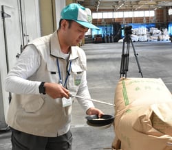 米袋から玄米抜き出す手塚富康係長（長野県安曇野市で）