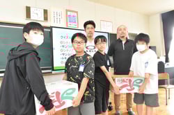 リンゴ「つがる」を贈呈する伊藤さんと大倉さん