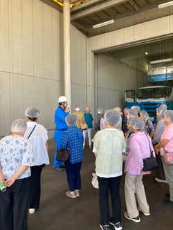こめ油製造工程の説明を聞く参加者