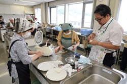 参加者とおにぎりを握る滝本さん