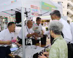 来場者に花束を手渡す役職員