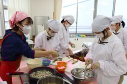 女性部員のサポートで調理を進める生徒ら