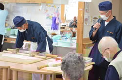 そば打ちを披露する桜井さん（左）と説明する矢島会長