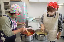 トマトベースの野菜ソースづくりを行う女性大学院生