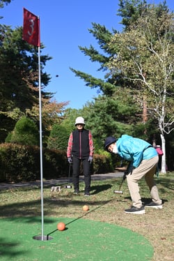 秋晴れのもと、マレットゴルフを楽しむ会員たち