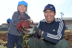 百瀬支部長（右）と園児（左）がさつまいもを収穫