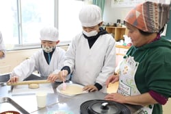 メンバーと一緒にピザ生地をつくる児童