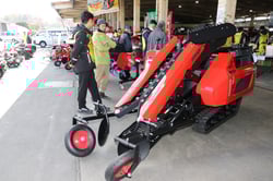 ネギの収穫機械を観察する来場者