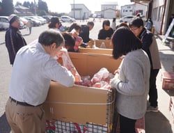 袋入りのリンゴを買い求める来場者