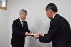 寄付金を手渡す辰ノ口支所長（右）